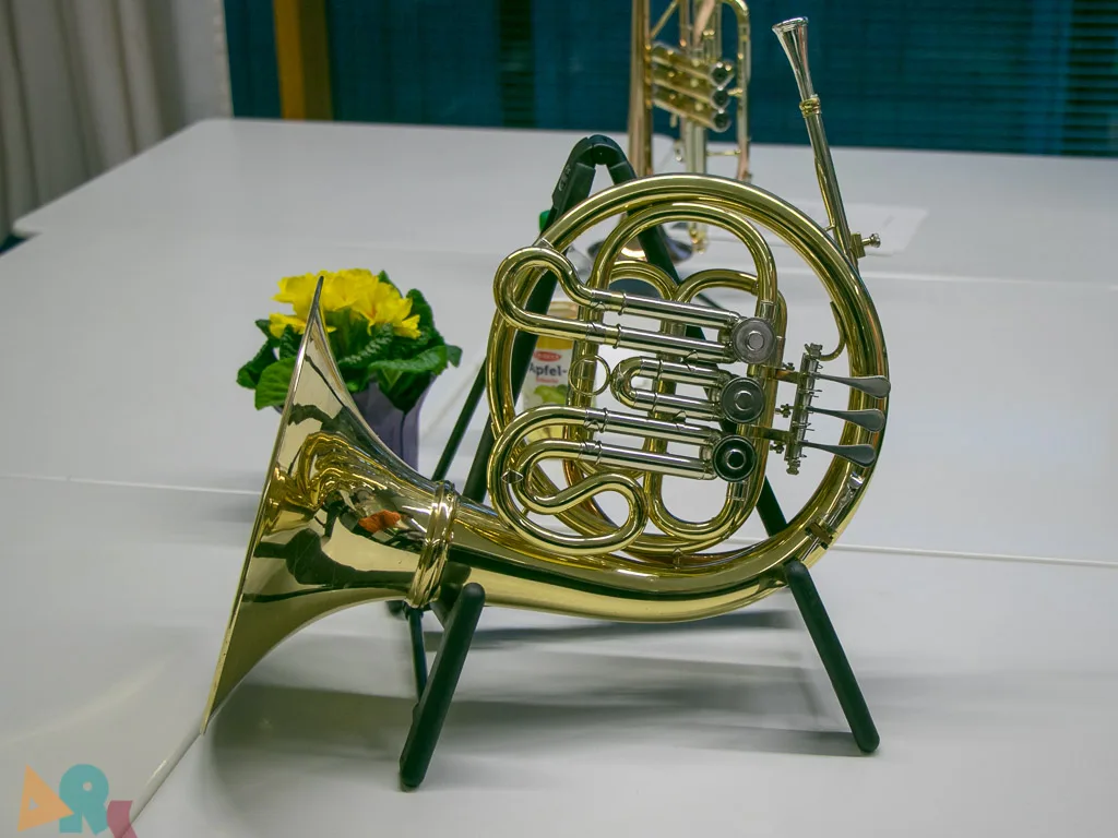 Waldhorn auf einem Ständer neben Blumen.